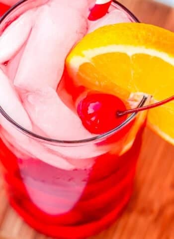 A Shirley Temple Drink garnished with an orange slice and maraschino cherry.