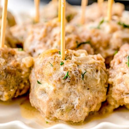 A close up picture of the Swedish Meatball Appetizer on a serving plate with toothpicks in the meatballs.