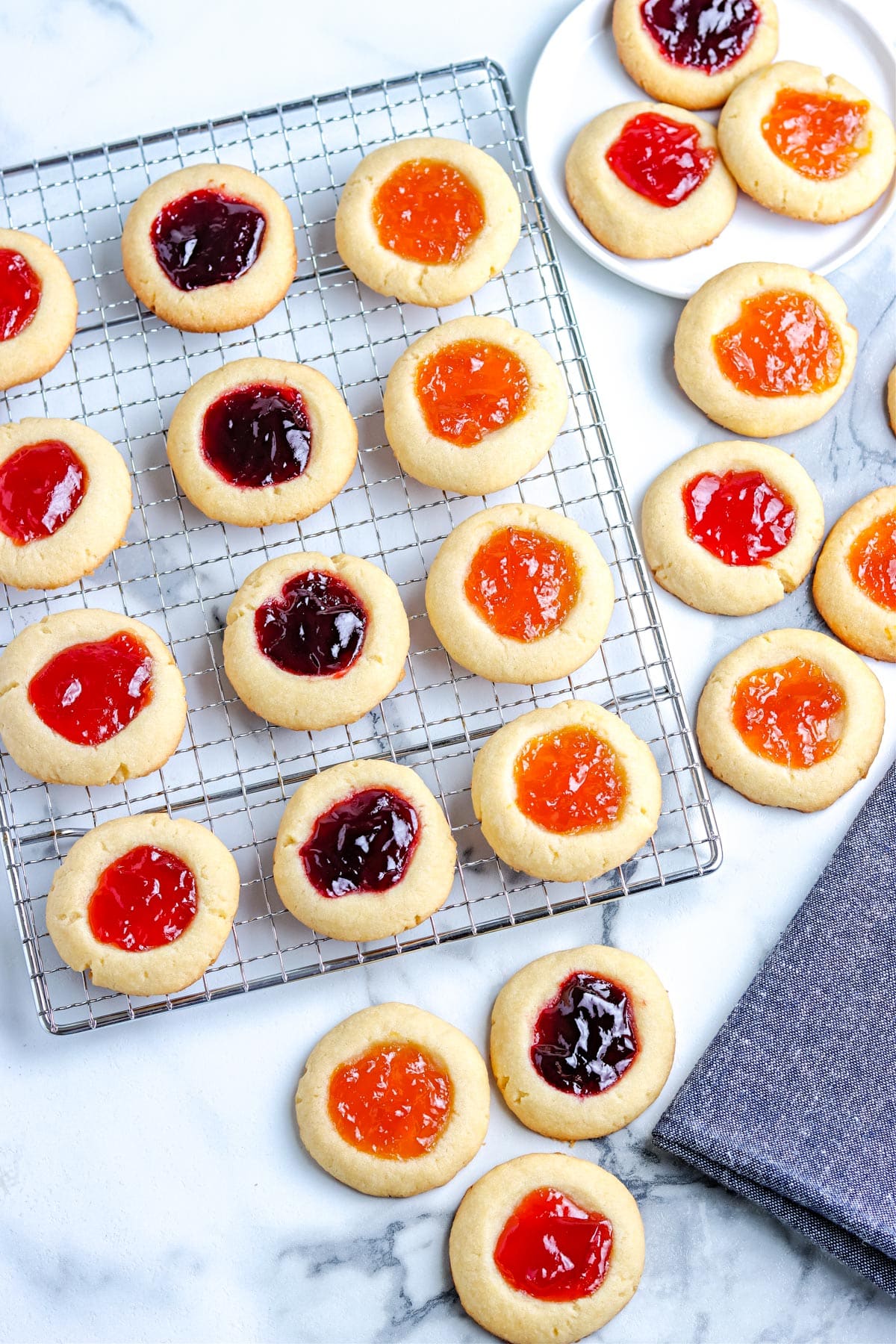 An overhead picture of the finished Thumbprint Cookies With Jam on a wire cooling rack.