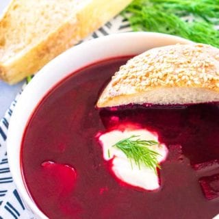 A bowl of Polish Beet Soup with a side of bread