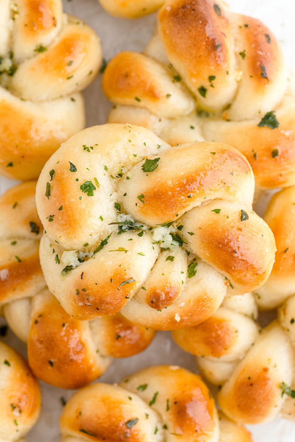 A pile of garlic knots on a white platter.