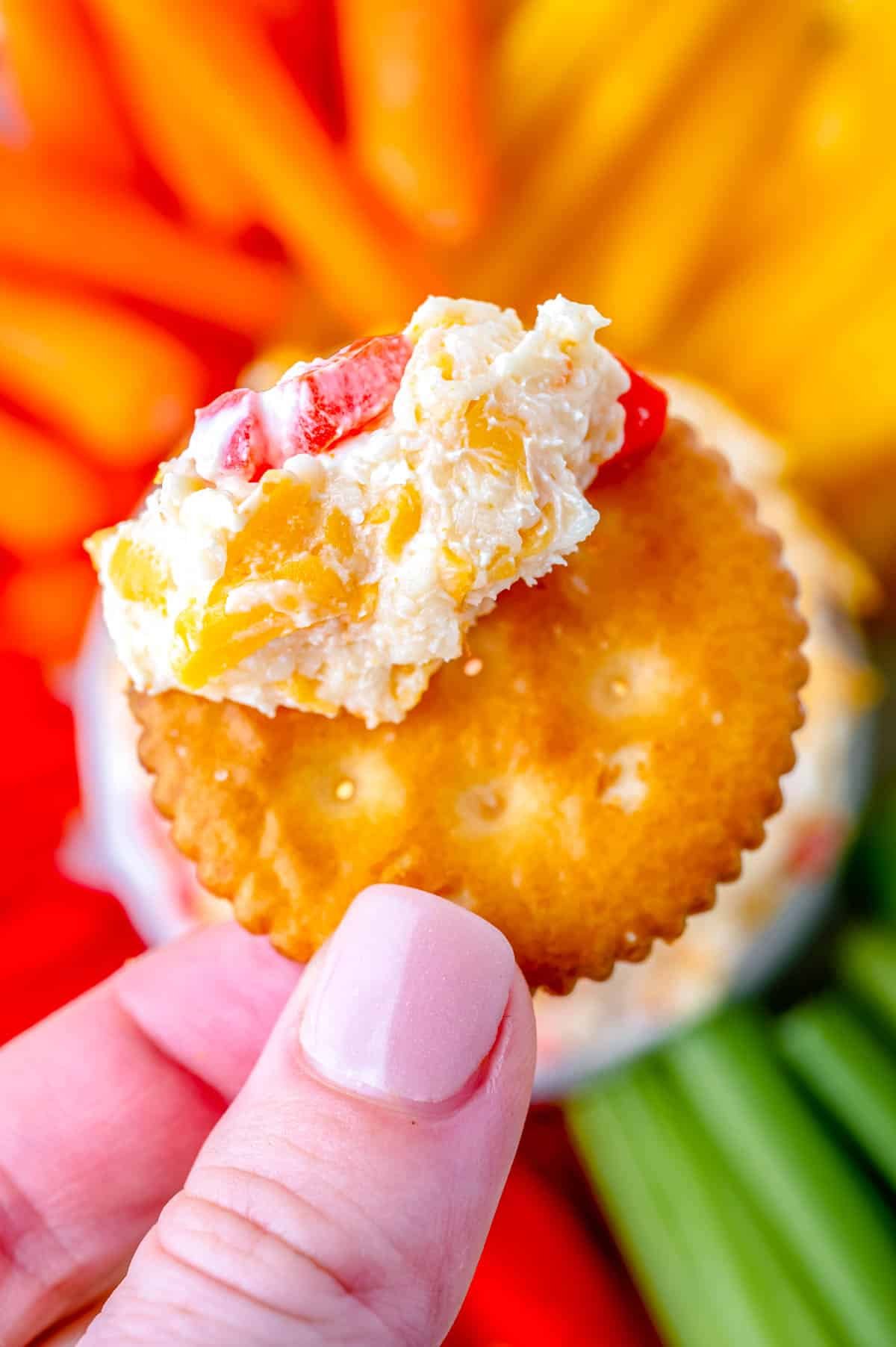 A close up picture of Pimento Cheese spread on a Ritz cracker.