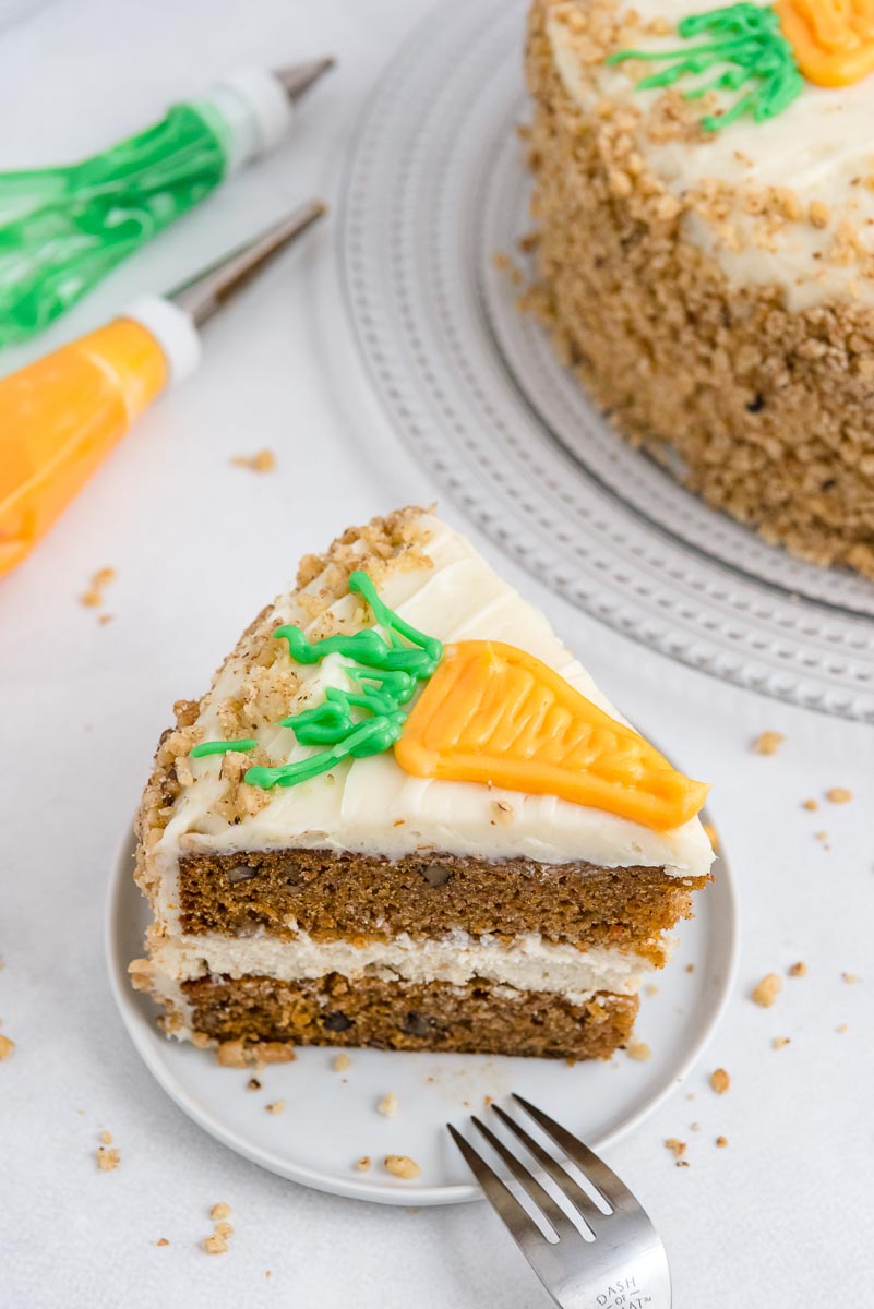 A slice of Cheesecake Factory Carrot Cake Copycat on a white plate. 