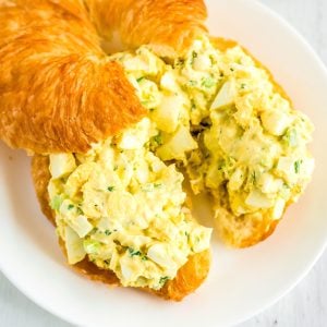 A close up picture of this egg salad recipe with dill on a split croissant.