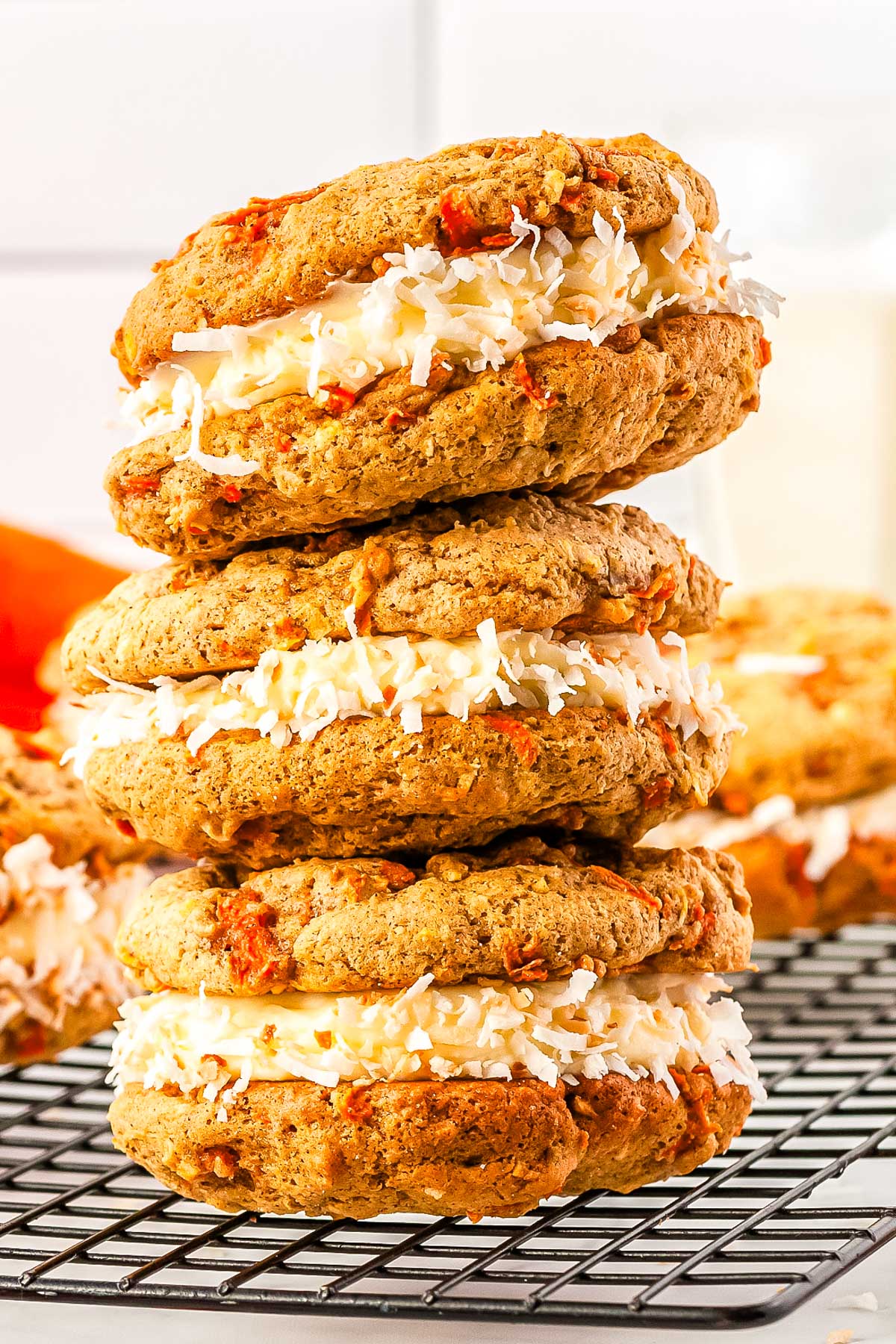 Three of the finished Carrot Cake Whoopie Pies recipes are stacked on top of each other.