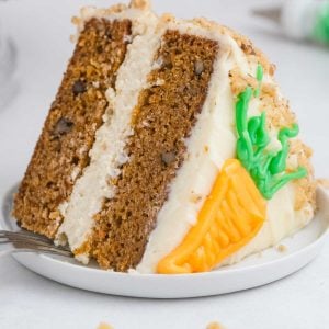 A close up picture of a slice of Cheesecake Factory Carrot Cake Copycat on a white plate.