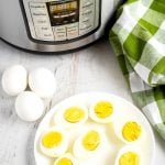 Hard-boiled eggs on a plate with an Instant Pot in the background