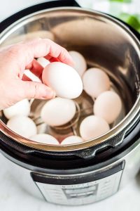 Placing eggs in the Instant Pot to hard boil them