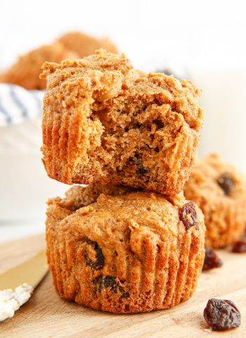Two Bran Muffins stacked on top of each other. The top one has a bite taken out of it.