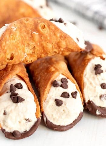 Cannolis stacked on top of each other.
