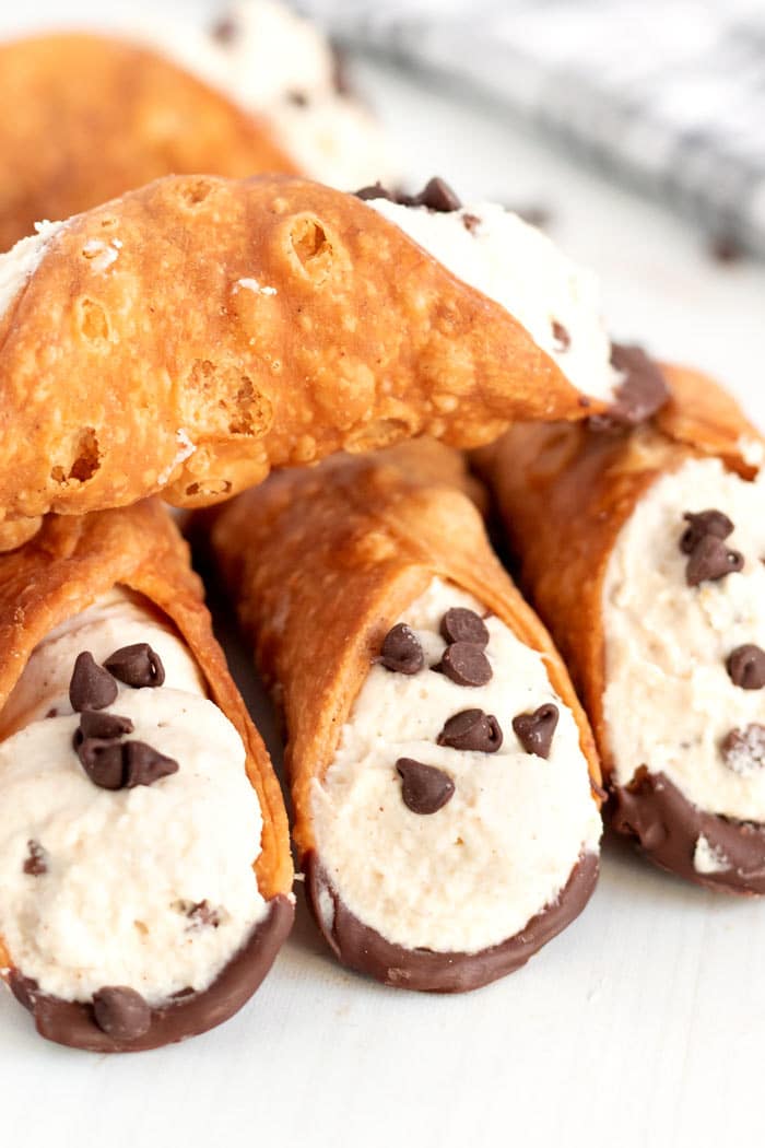 Cannolis stacked on top of each other.