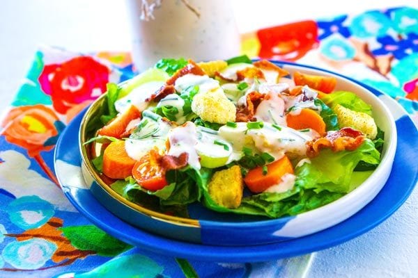 Salad on a plate that is drizzled with homemade ranch dressing.