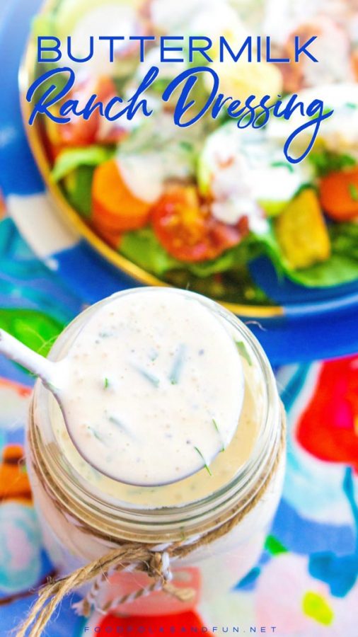 Ranch dressing in a Mason jar being ladled over a salad.