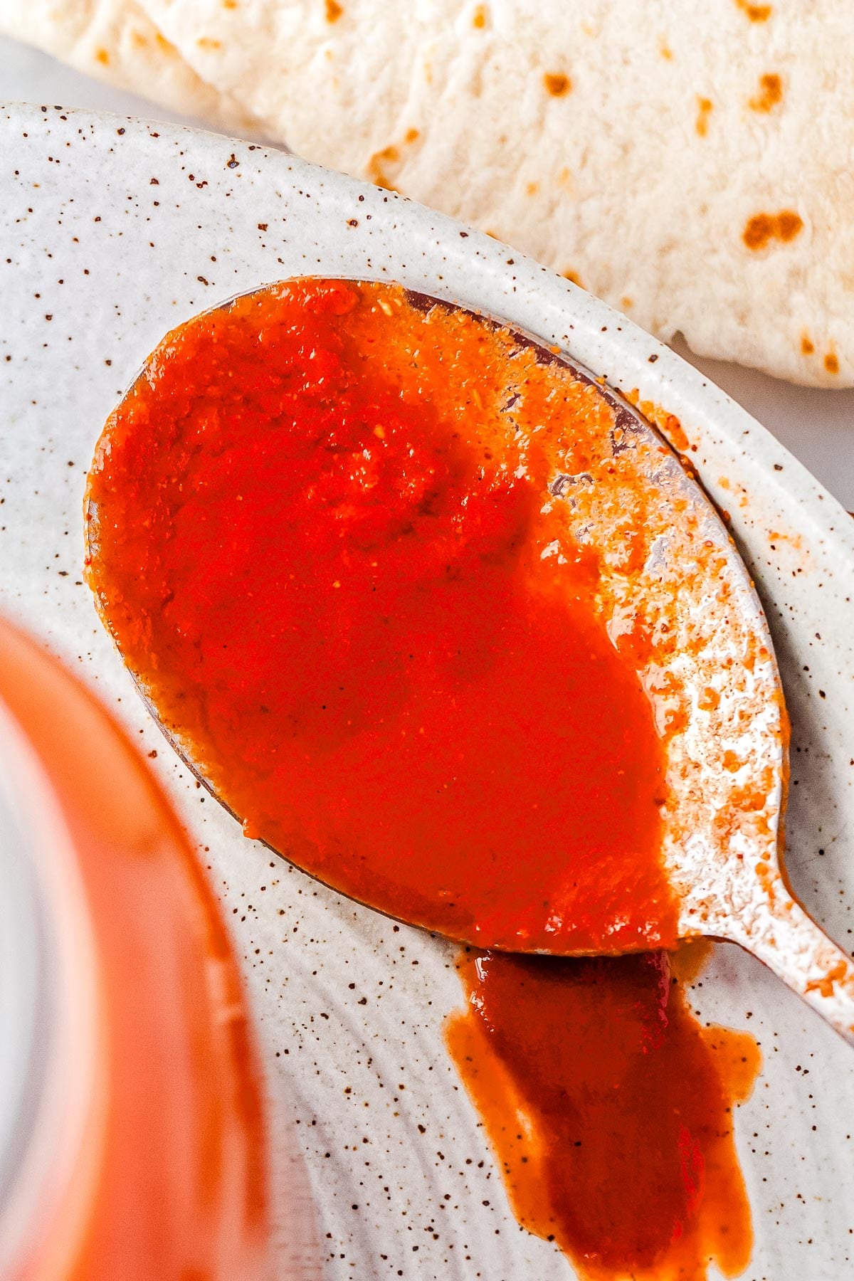 A spoon with chipotle enchilada sauce on it.