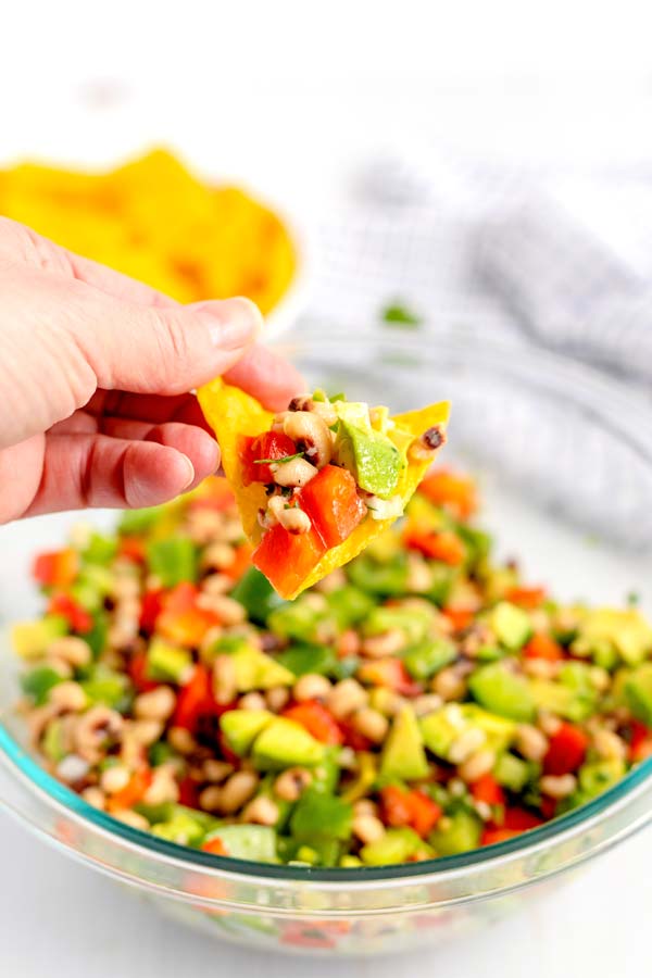 A chip being dipped into the cowboy caviar recipe.