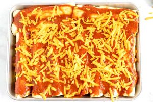 Sprinkle with cheddar cheese and cook the enchiladas for 22 minutes.