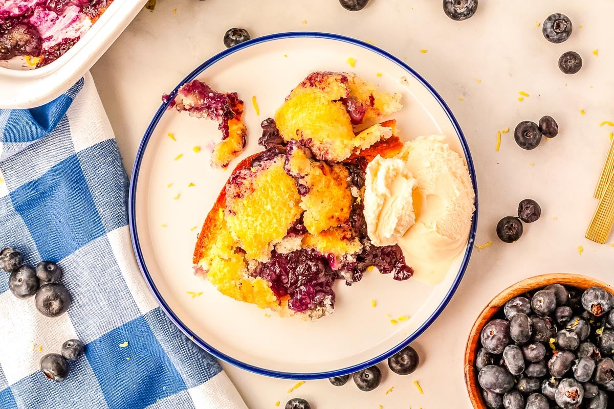 A scoop of lemon blueberry cobbler on a plate with vanilla ice cream.
