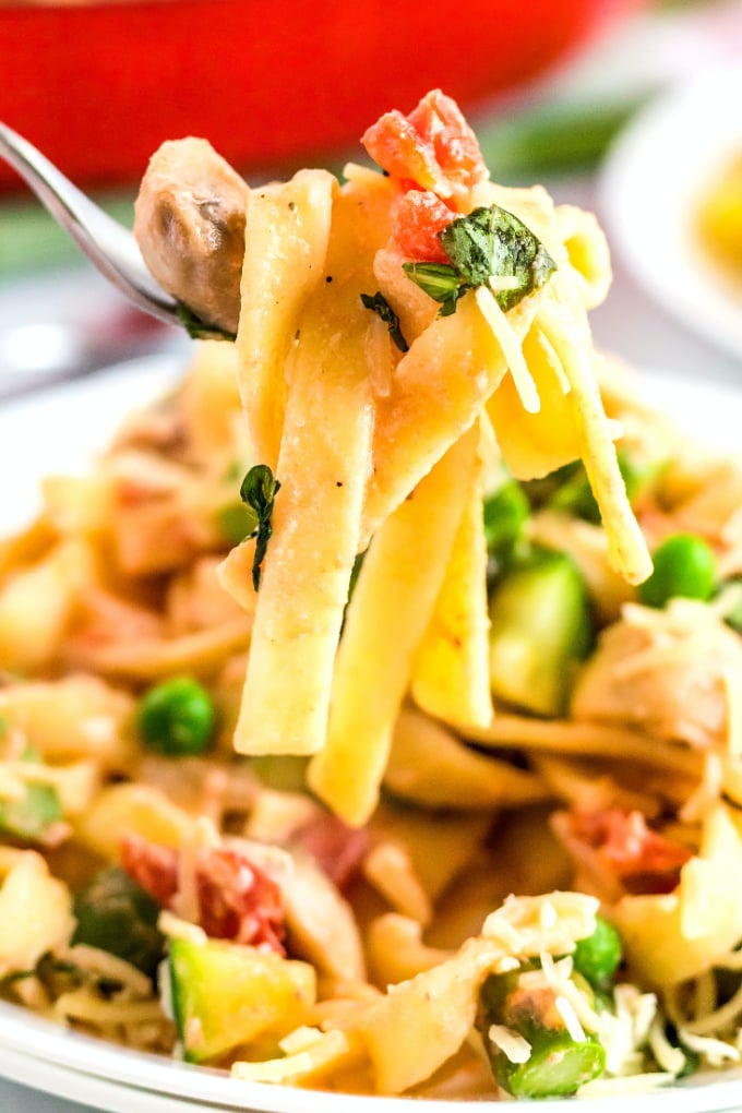 A close up picture of a fork listing up some Pasta Primavera