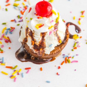 An overhead picture of a brownie ice cream sundae with sprinkles all around.