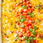 Stacked green chile enchiladas in a white pan.