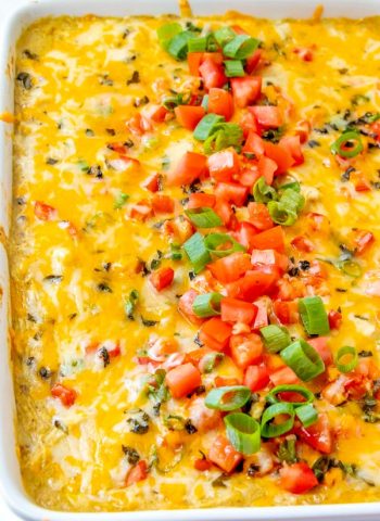 Stacked green chile enchiladas in a white pan.