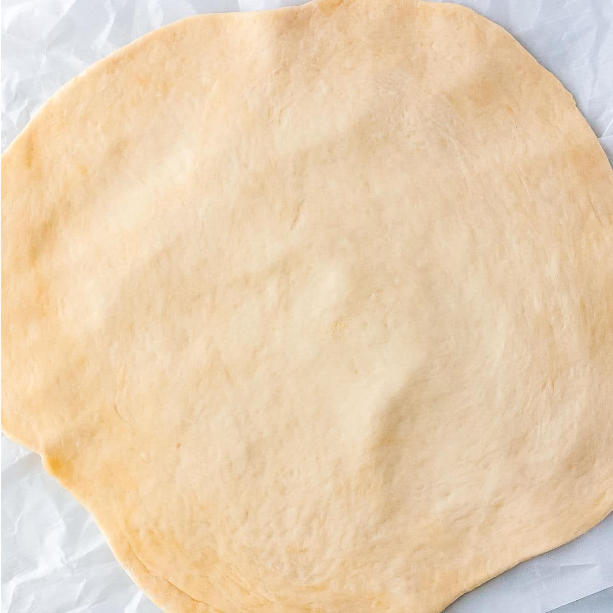 The pizza dough rolled out to a 12-inch circle.