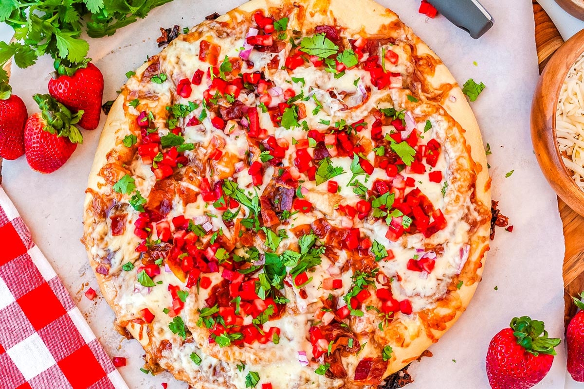 The finished pizza on a serving platter garnished with cilantro.