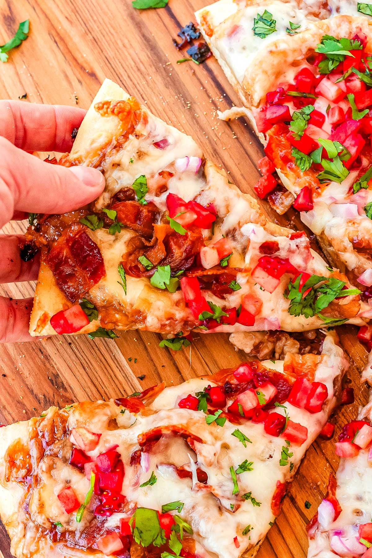 a hand pickingup a slice of pizza.
