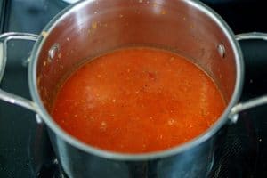 Add the tomatoes to the pot and cook.