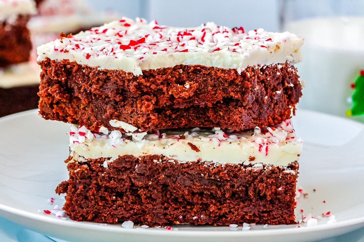 Two Peppermint Bark Brownies stacked on each other with a bite taken out of the top one.