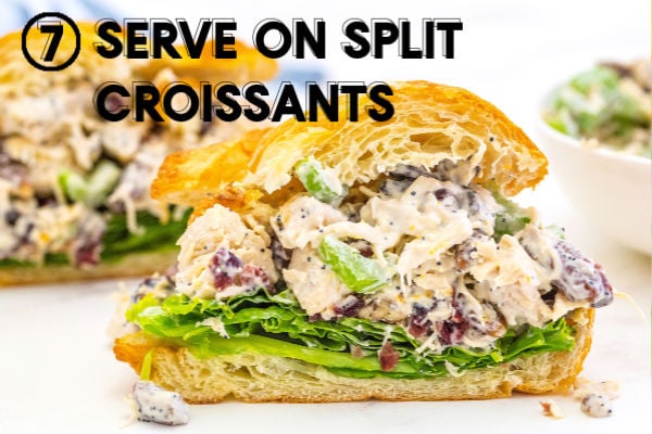 chicken salad served on a split croissant with some lettuce.