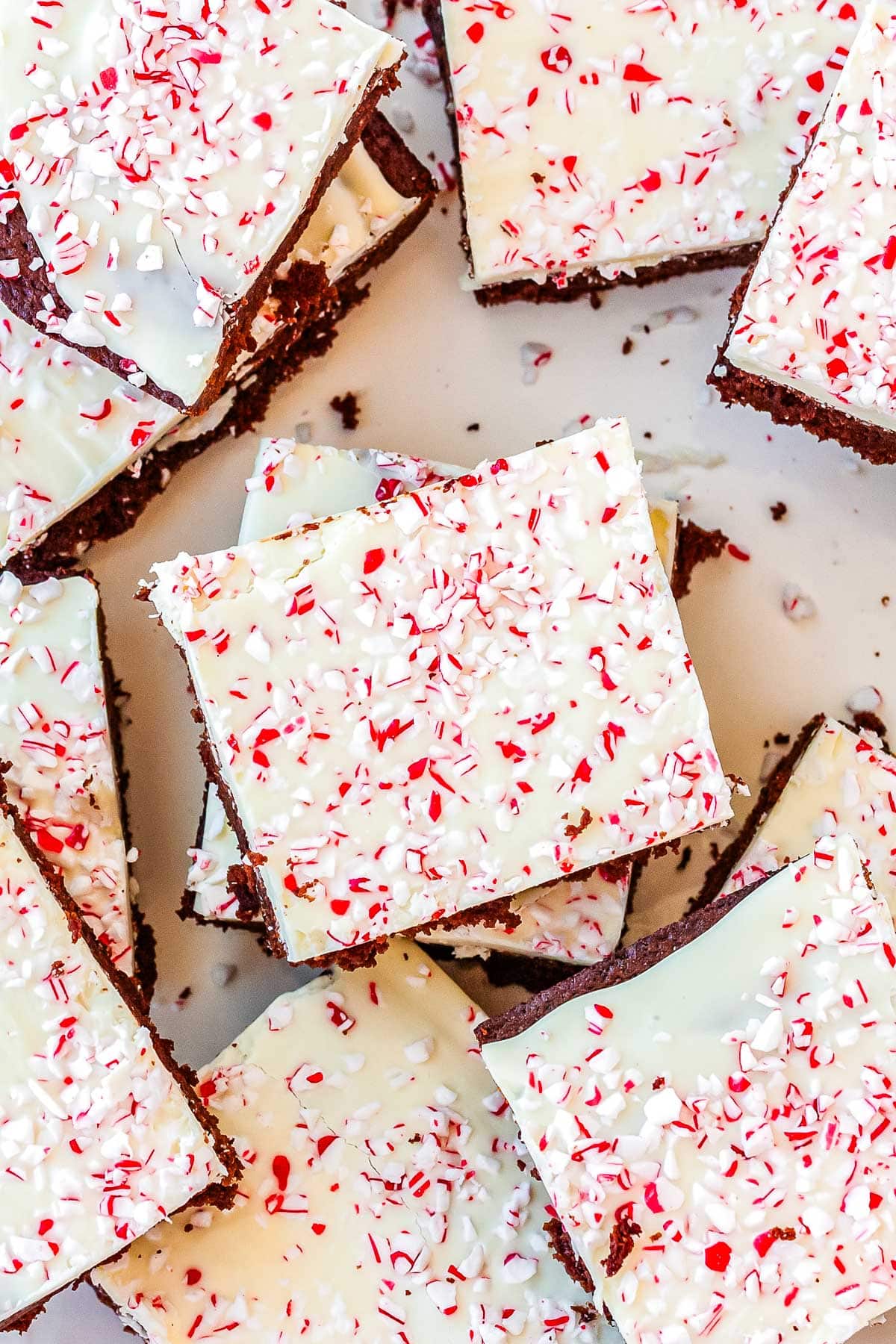 Cut Peppermint Bark Brownies stacked on a serving dish.