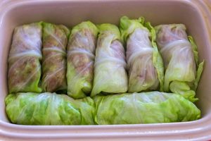 Lay the rolled cabbage leaves neatly in the prepared baking dishes.
