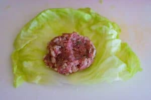 Place 2 Tablespoons of the filling on the bottom half of the cabbage leaf.