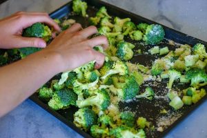 Place the broccoli on a baking sheet and mix with olive oil, lemon zest, and salt and pepper.