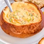 Copycat Panera Broccoli Cheddar Soup in a bread bowl with a spoon.