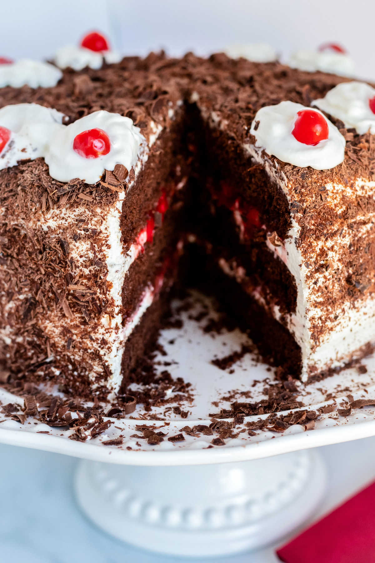 A picture of the black forest chocolate cake with a slice taken out of it.