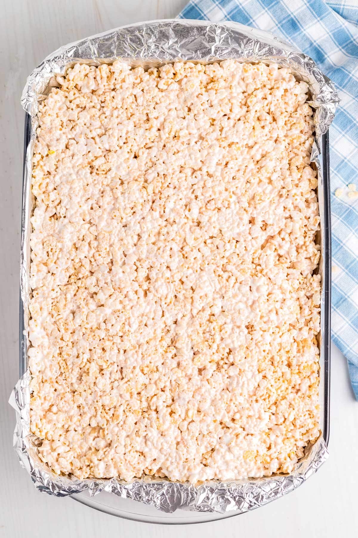 The rice krispie mixture pressed into the prepared pan with foil.