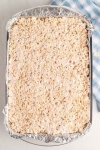 Pour the Rice Krispies mixture into the prepared pan and press the treats into the pan using wax paper.