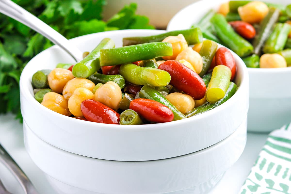 A close-up of bean salad in a white bowl.