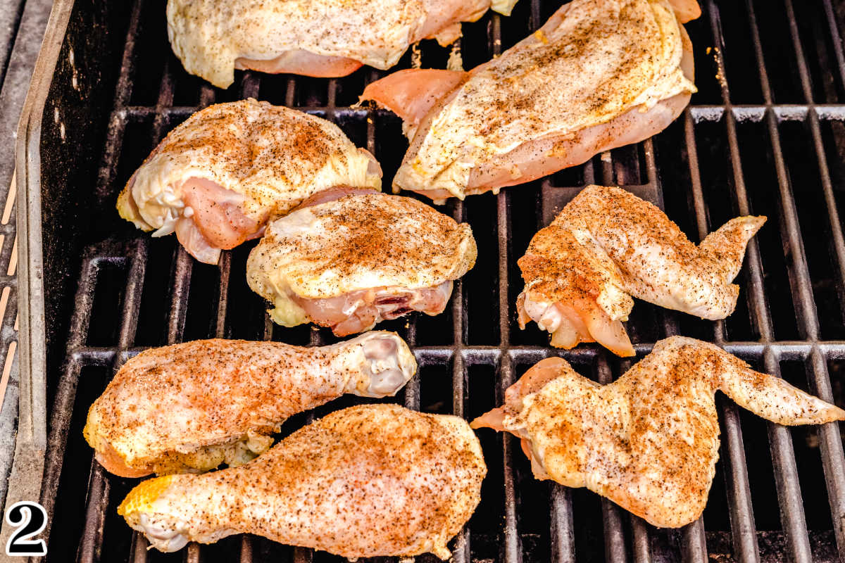 The chicken pieces cooking on the cold side of the grill.