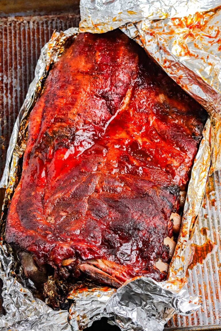 The finished smoked ribs recipe in a foil packet with the top of the foil peeled back.