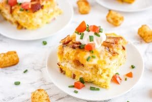 Slices of Tater Tot Breakfast Casserole on white plates.