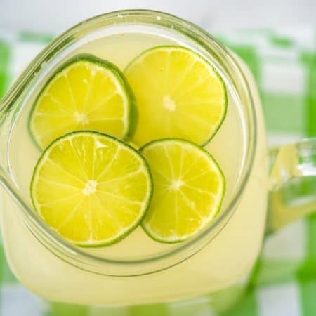 Overhead picture of a pitcher of limeade with lime slices floating in it.