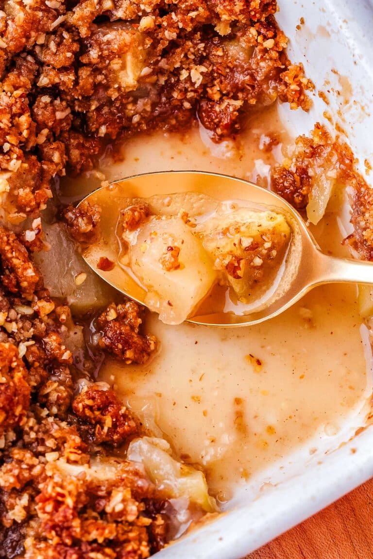 A spoon picking up some of the finished apple crisp.