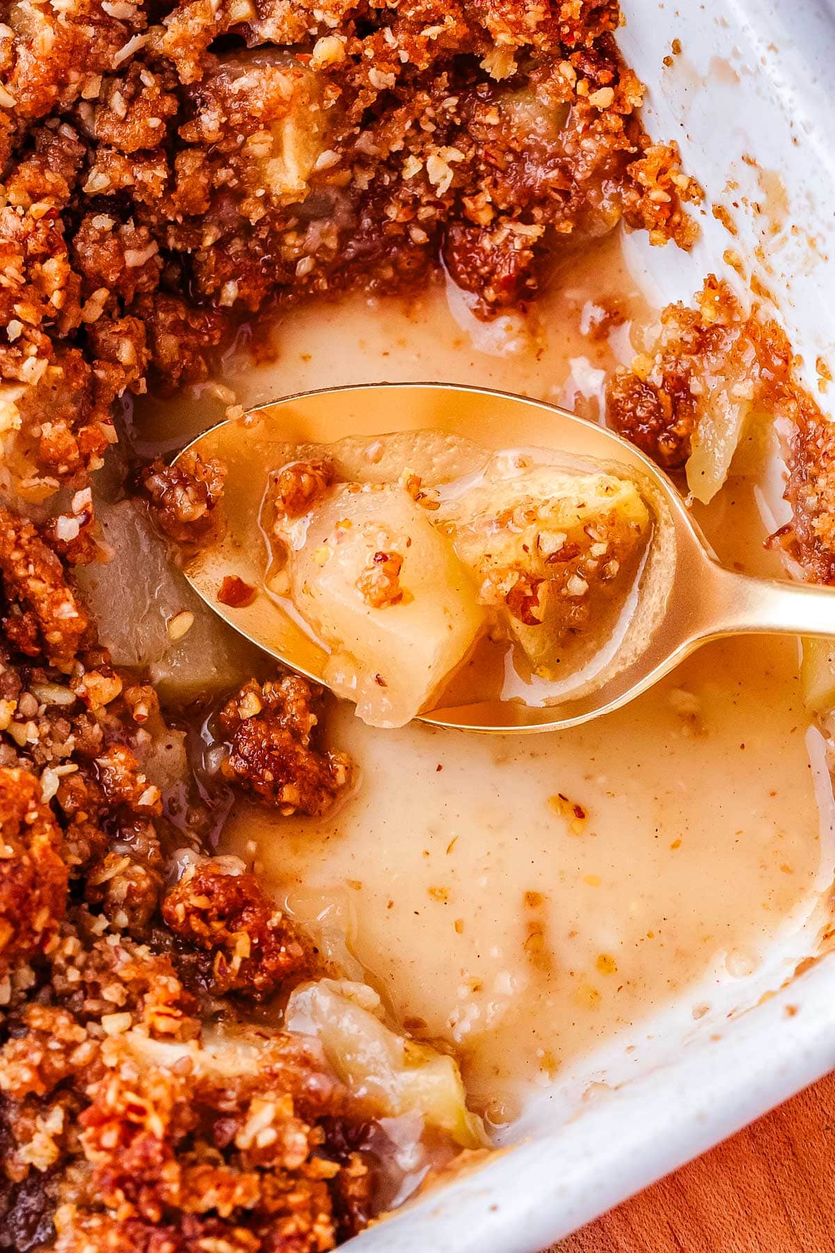 A spoon picking up some of the finished apple crisp.