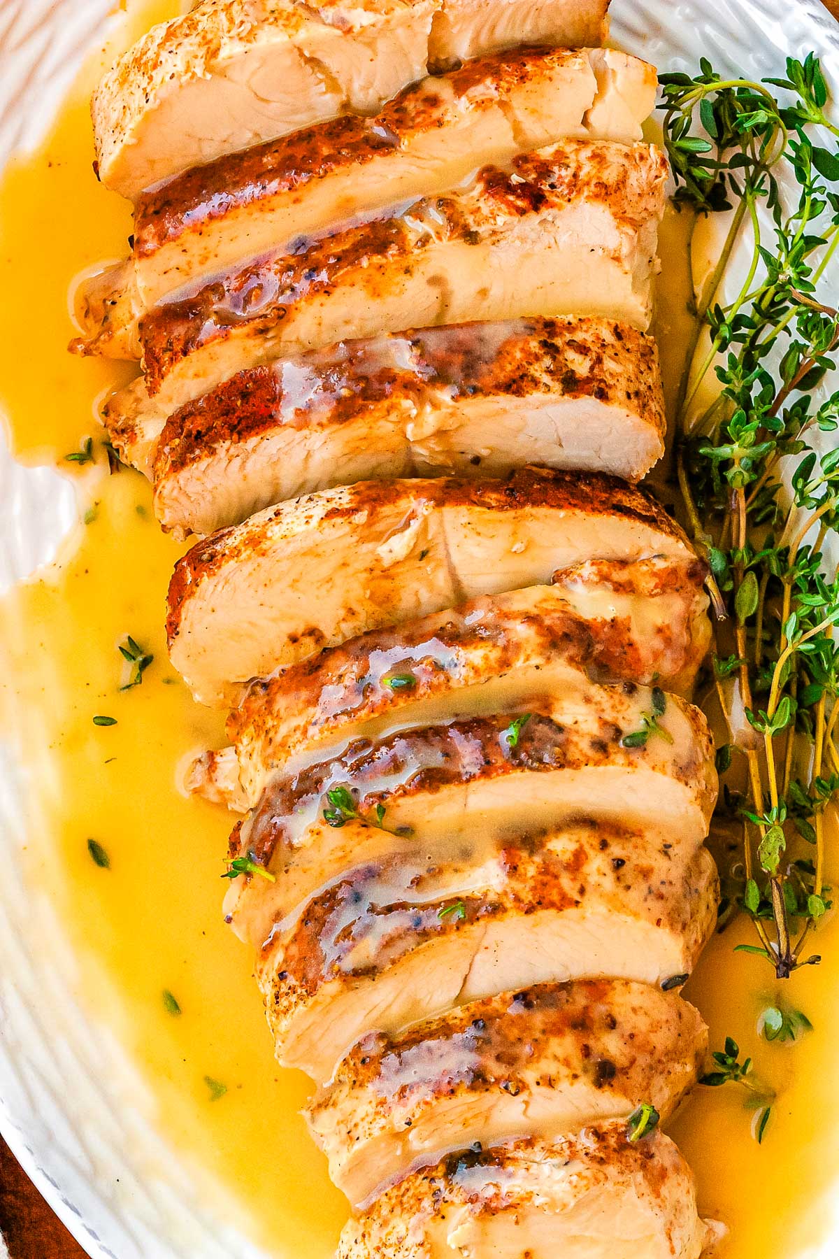 Slices of turkey breast on a platter with turkey gravy poured over it.
