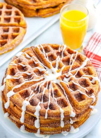 Three Churro Waffles stacked on a white plate.