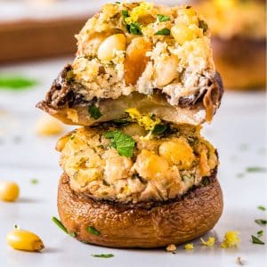 Two Stuffed Mushrooms stacked on top of each other, one is bitten into.