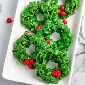 5 Christmas wreath cookies on a white serving platter.